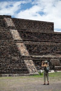 A tourist frames her shot of one of the many pyramids in Teotihuacan