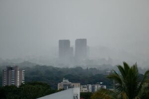 Like thick fog, the rain embraces distant apartment buildings in San Salvador