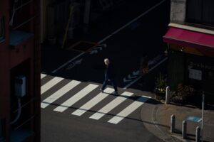 A morning pedestrian walks the streets of Tokyo between light and shadows