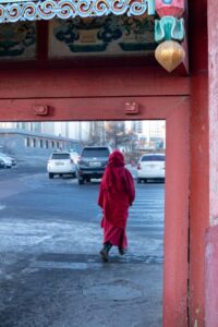Woman with red robes leaving the monastery Woman with red robes leaving the monastery